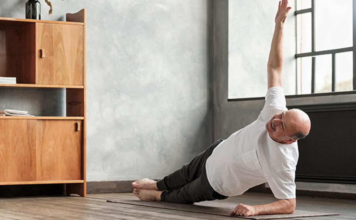 man doing a side plank exercise at living room.