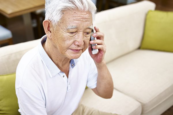 sad senior asian man talking on cellphone