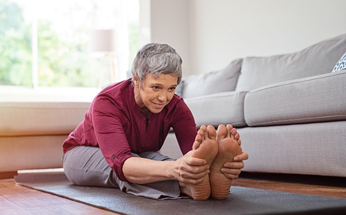 Mature woman doing yoga exercise at home