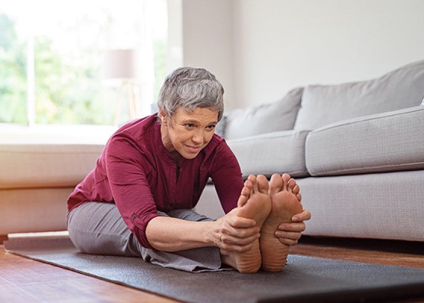 Mature woman doing yoga exercise at home