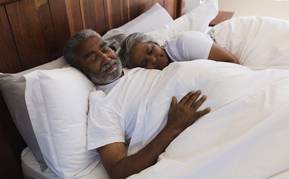 Senior couple sleeping together in bedroom